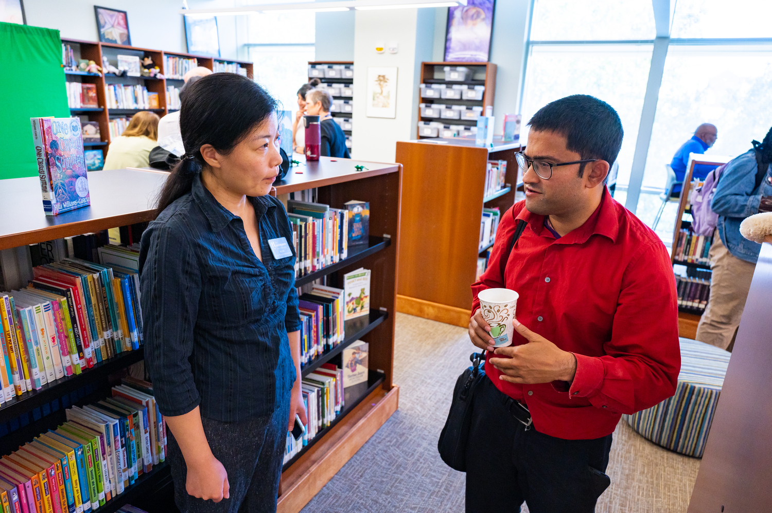 two people chatting in a library