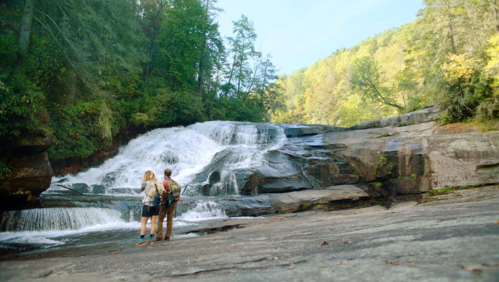 Waterfall surrounded by mountains and trees