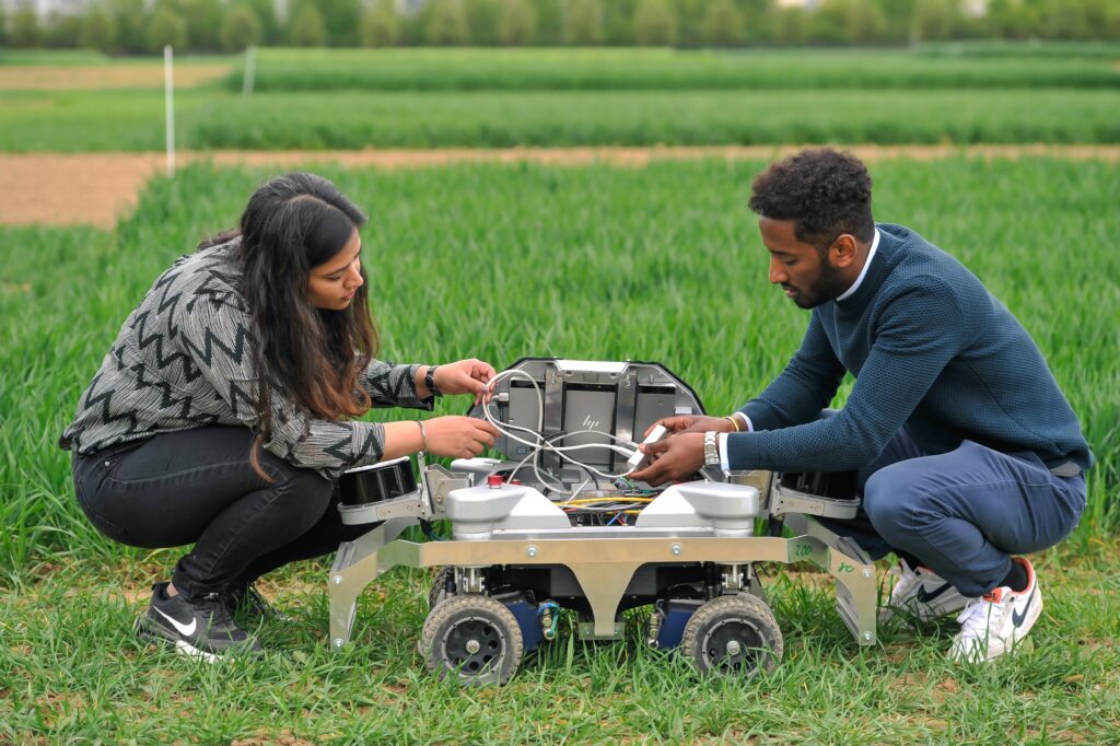 Hohenheim students with a robot in a field